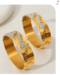 Detailed view of hollow floral pattern and inlaid rhinestones on 18K gold plated bangles