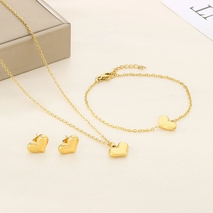 Flat lay of 18K gold plated heart necklace, bracelet and earrings jewelry set
