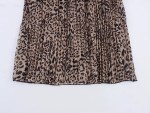 Dettaglio ravvicinato della stampa leopardata e della trama a pieghe della gonna in chiffon