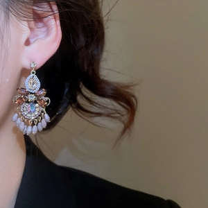 Nahaufnahme eleganter Kristall-Ohrhänger mit lavendelfarbenen Perlen am Modell