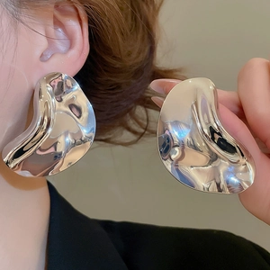 Detailed view of large liquid metal silver drop earrings with a polished mirror finish