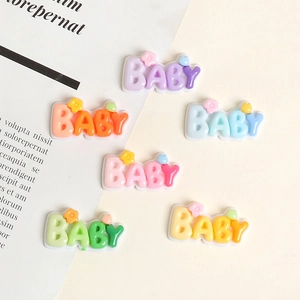Macro detail of colorful resin BABY letter charms with small flower accents for DIY crafts