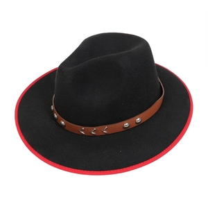 Close-up of black felt fedora featuring red piping and leather band with metal studs
