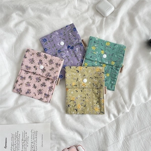 Flat lay of four colorful floral quilted cotton sanitary pouches with snap button closures