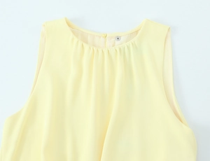 Detail of light yellow sleeveless midi dress featuring pleated round neck and back button