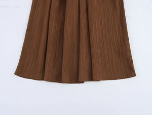 Detailed view of dark brown pleated fabric texture and vertical pleats on the vacation skirt