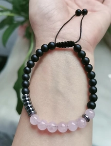 Detail of Morse code beaded bracelet with rose quartz and black matte beads on wrist