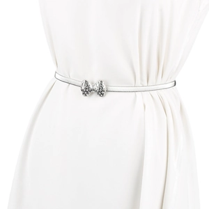 Détail de la ceinture élastique argentée avec boucle nœud papillon ornée de strass