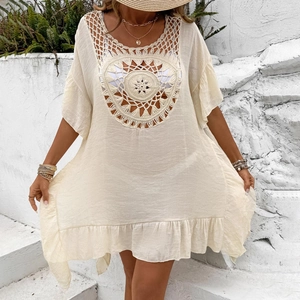 Close-up of crochet hollow-out pattern and V-neck detail on the cream beach cover-up dress