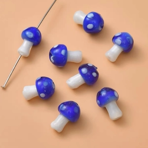 Macro shot of blue and white mushroom glass beads with needle for DIY jewelry making