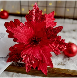 Macro shot of a red poinsettia Christmas flower with sequins and festive background