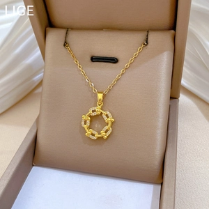 Close-up of golden spinning circle pendant with sparkling crystals in a beige jewelry box