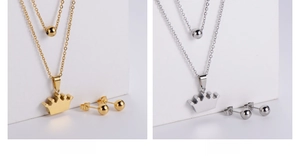 Close-up of dual-layer crown pendant necklace and bead earrings in gold and steel finish
