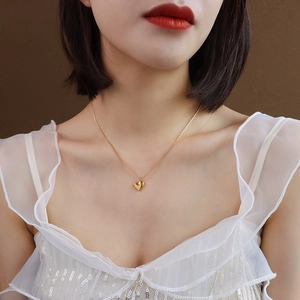 Minimalist 18k gold plated stainless steel heart necklace worn by a female model