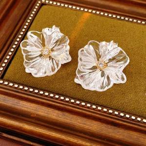 Macro di eleganti orecchini floreali con petali trasparenti e uno scintillante strass centrale