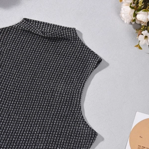 Gros plan du micro-col montant et de la maille texturée noire et blanche du haut