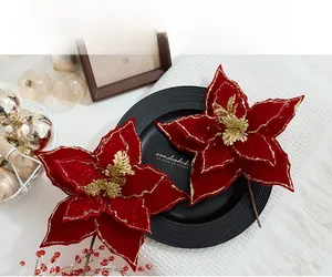 Close-up of velvet poinsettia flowers with gold glitter edges for Christmas decor
