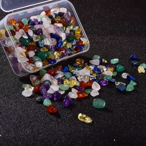 Macro view of assorted 5-8mm natural gemstone chips spilling from a transparent box