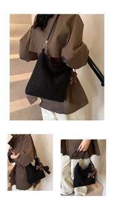 Macro detail of black wool blend bucket bag featuring a brown leather horse charm accessory