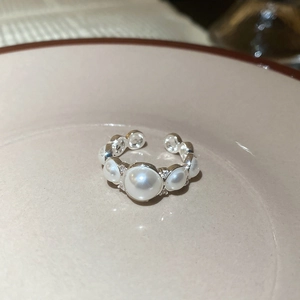 Macro shot of silver open ring with gradient pearls and sparkling zircon accents
