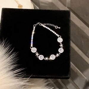 Detail of flower bracelet with five white chalcedony stones and zircon inlay on black velvet