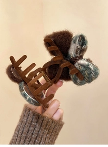 Detailed view of a vintage brown flocked bow hair claw clip with knit texture details