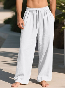 Detail of white cotton linen trousers showing elastic drawstring waist and loose fit