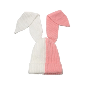 Detail shot of pink and white patchwork knitted hat with long rabbit ears for winter