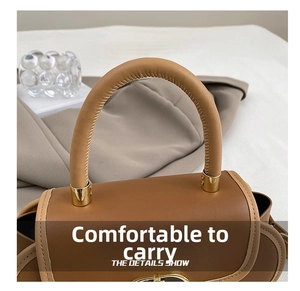 Dettaglio del manico in pelle marrone con accenti in metallo dorato della borsa donna
