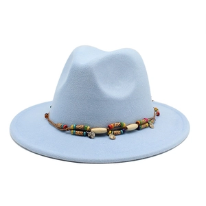 Détail d'un chapeau fedora bleu clair en laine avec ruban perlé ethnique