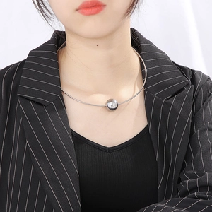 Detail of silver hollow steel ball pendant on minimalist punk style choker necklace