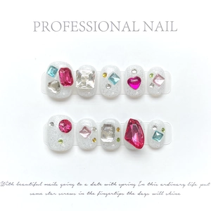 Close-up of handmade brown press-on nails with sparkling rhinestones and heart gems