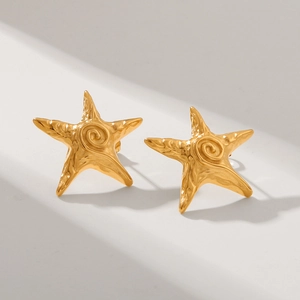 Macro detail of 18k gold star earrings showing the hammered texture and spiral pattern