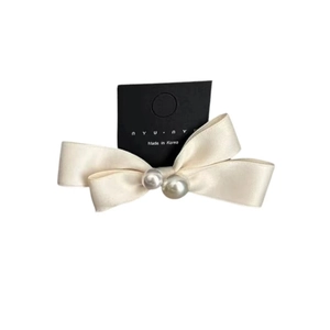 Elegant ivory silk satin bow hair clip with faux pearl accents on display card
