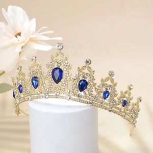 Detailed close-up of Baroque golden crown with pear-cut sapphire blue crystals and white diamonds