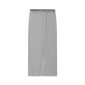 Detail view of knitted midi skirt featuring contrast plaid patchwork waist and center slit