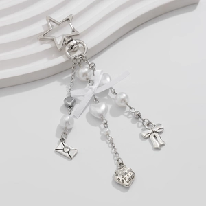 Detail of silver star keychain with pearls, strawberry, and white ribbon bow