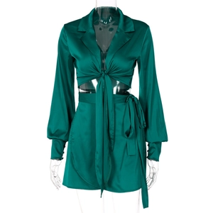 Détail de l'ensemble deux pièces en satin vert émeraude avec haut à lacets et mini-jupe