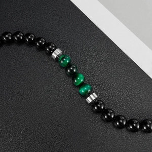 Detail of tiger eye and beryl beads on stainless steel bracelet with silver spacers