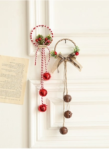 Detail of Christmas tree bell ornaments in red and rustic brown hanging on a white wall
