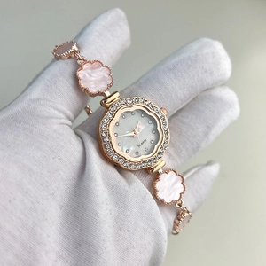 Detail of rose gold flower link bracelet watch with pink inlay and crystal bezel