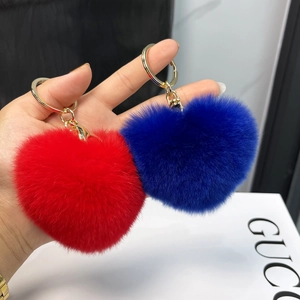Detail of soft heart-shaped plush keychains in vibrant red and royal blue with gold rings