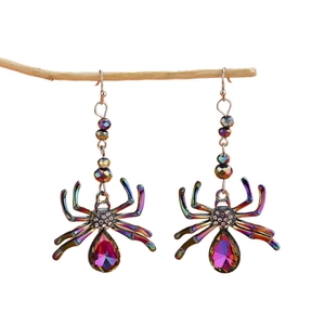 Colorful spider earrings with crystals and teardrop pendant on a wooden branch