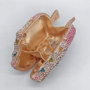 Close-up of apple-shaped evening clutch with colorful rhinestones and gold interior