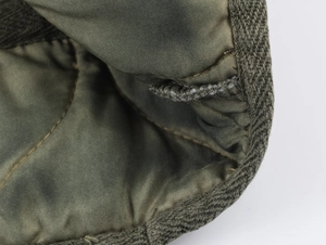 Macro detail of military green quilted twill fabric lining with high-quality stitching