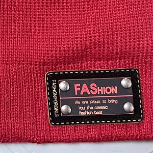 Bonnet en tricot rouge doublé polaire avec écusson en cuir mode et rivets métalliques