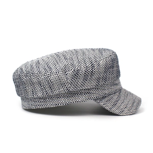 Close-up detail of grey mixed tweed fabric and woven texture on a flat top military cap