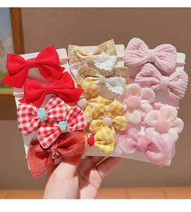 Detailed view of 11-piece girls bow and flower hair accessory set on display card