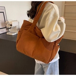 Texture détaillée du velours côtelé marron sur un grand sac cabas décontracté