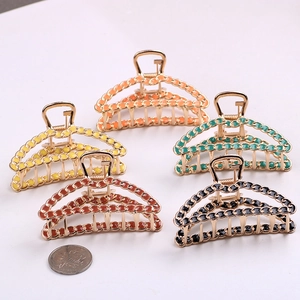 Detail of woven chain alloy hair claws in five colors next to a coin for scale